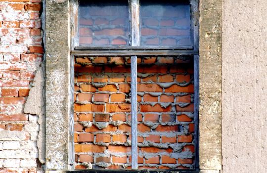 Vermauertes Fenster in alter Backsteinwand.